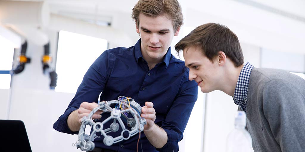 Two students examine a piece of technology.