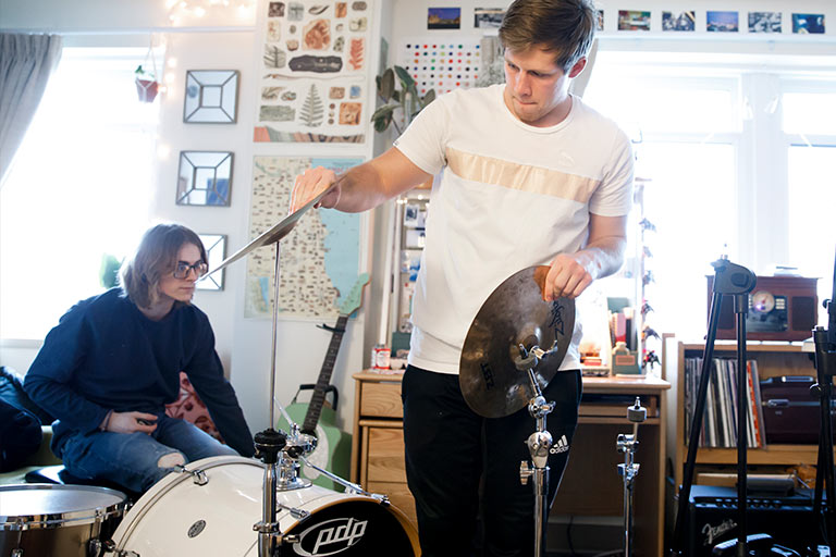 A student sets up a drum kit.