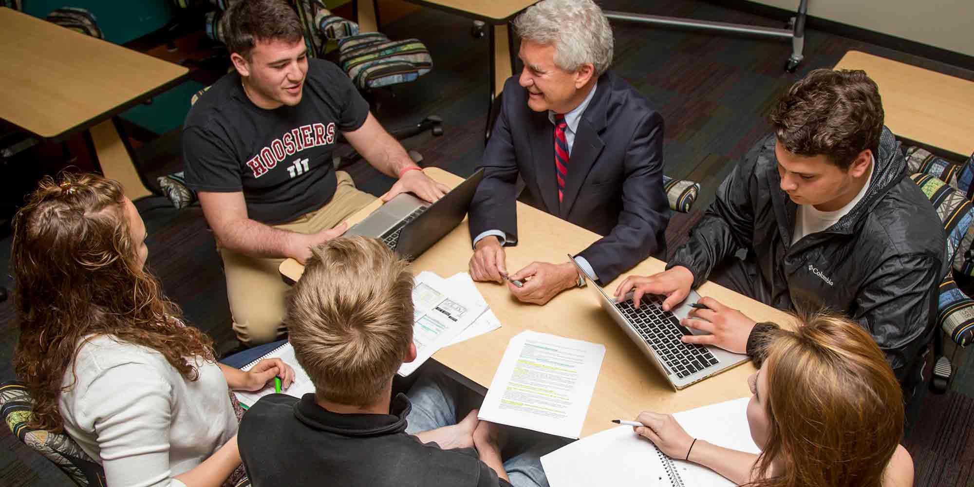 Professor with students gathered at a table